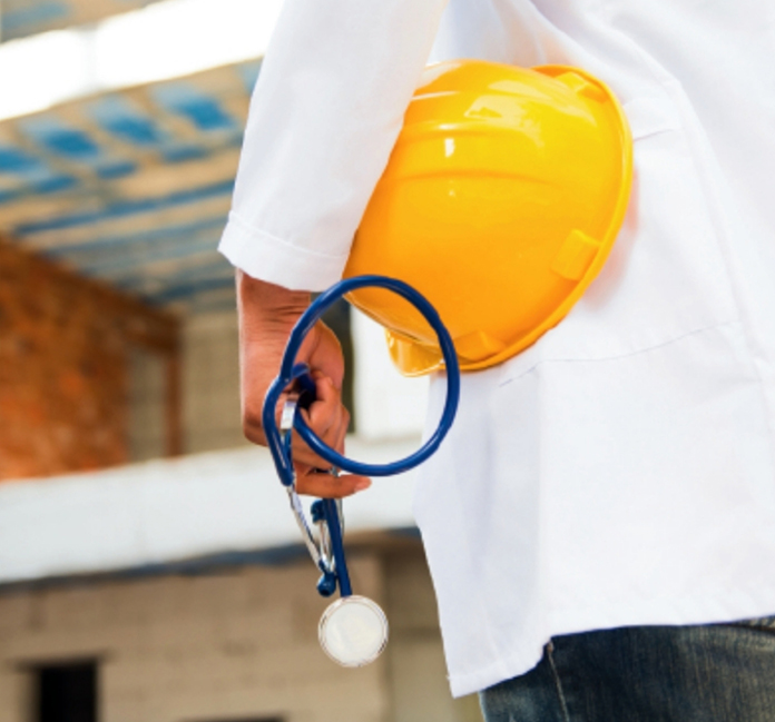Healthcare professional holding a safety helmet and stethoscope, with no face visible
